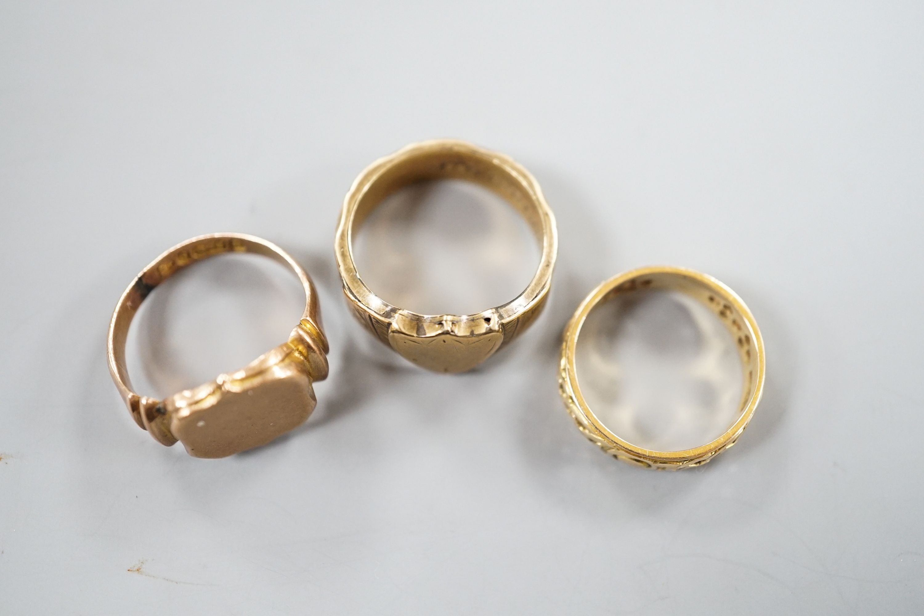 A Scottish pierced 14ct gold band, hallmarked for Edinburgh, 1962?, maker G & TW, size K/L, 3.8 grams and two 9ct gold signet rings, including one with plaited hair within the shank, hallmarked for Chester, 1881, gross 8